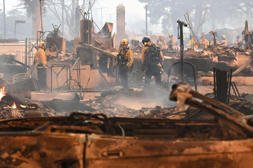 Firefighters work inside a burned structure while battling the Eaton Fire, Wednesday, Jan. 8, 2025, in Altadena, Calif. (AP Photo/Nic Coury)