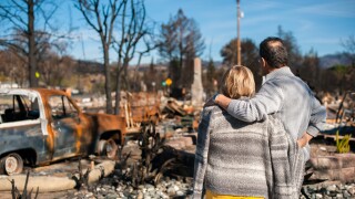 Couple checking ruins after fire disaster.