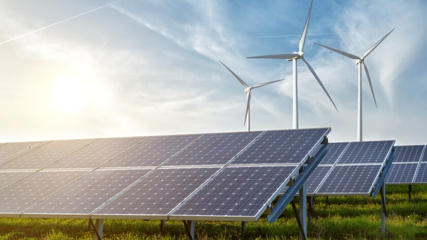 solar panels and wind generators under blue sky on sunset
