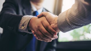 Two business men shaking hands during a meeting to sign agreement and become a business partner, enterprises, companies, confident, success dealing, contract between their firms
