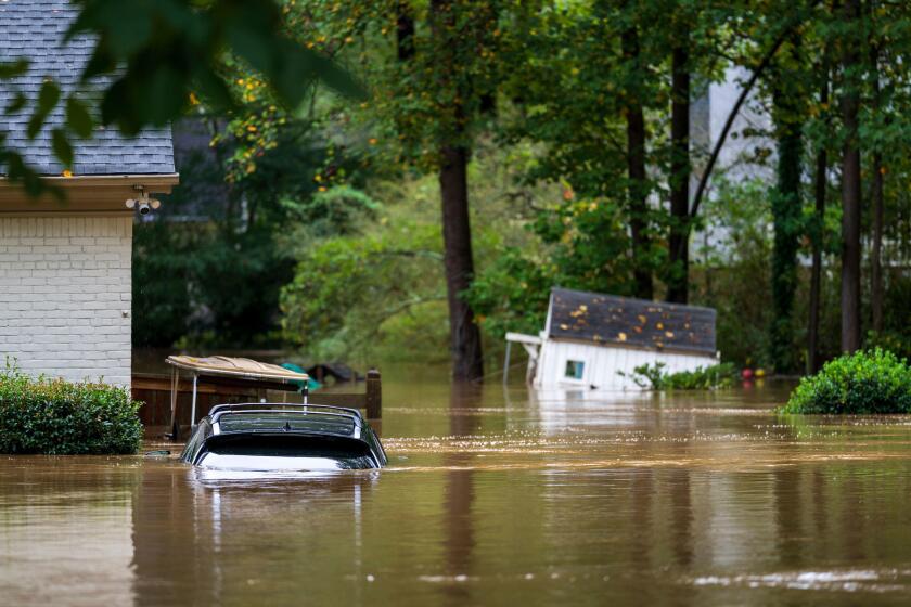 An vehicle, golf cart and playhouse are submerged from flooding Friday, Sept 27, 2024, in Atlanta. (AP Photo/Jason Allen)