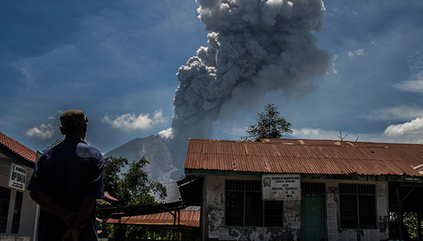Karo, North Sumatra, Indonesia. 25th May, 2017. A resident watched as Sinabung volcano spews rolling thick volcanic ash into the air, as seen from Tiga Pancur village on May 25, 2017, North Sumatra province, Indonesia. The activity of Mount Sinabung with