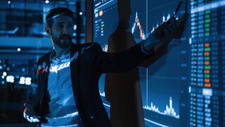 PE Business Conference Meeting Presentation: Businessman does Financial Analysis talks to Group of Businessspeople. Projector Screen Shows Stock Market Data, Investment Strategy, Revenue Growth