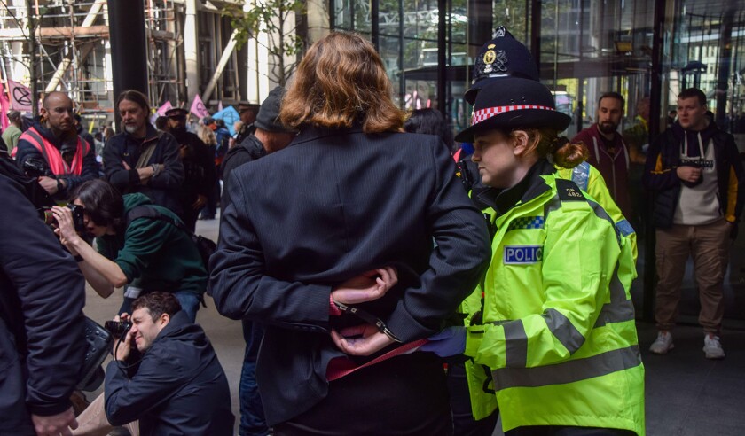London, UK. 29th October 2024. Police officers arrest Extinction Rebellion activists who spray-painted the office building of insurance company WTW in the City of London, on the second day of their three-day protest calling on insurance companies to stop