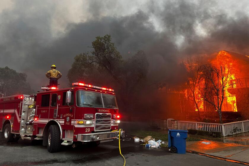 Firefighters battle the Palisades Fire as it burns structures in the Pacific Palisades neighborhood of Los Angeles, Wednesday, Jan. 8, 2025. (AP Photo/Eugene Garcia)
