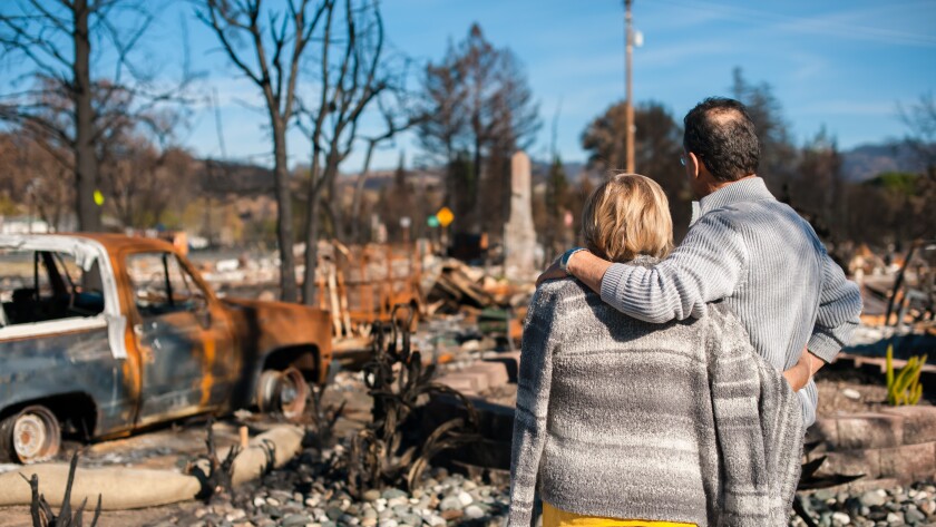 Couple checking ruins after fire disaster.