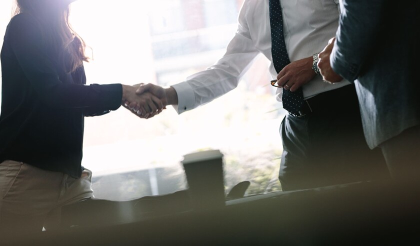 Business associates shaking hands after a deal in meeting. Business people hand shake and greeting each other after an agreement.