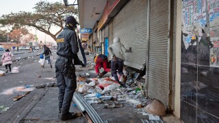 (210712) -- JOHANNESBURG, July 12, 2021 (Xinhua) -- A police officer deals with protesters looting a shop in Johannesburg, South Africa, on July 12, 2021. Soldiers have been deployed in KwaZulu-Natal and Gauteng provinces to deal with violent protests and