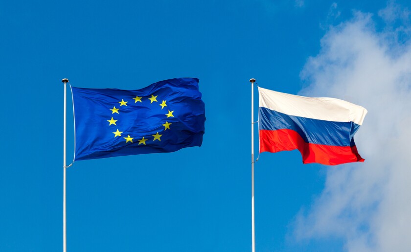 EU flag and Russia flag are on blue sky.