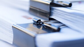 Piles of documents with black clip