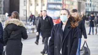 Young woman wearing face mask while walking in the streets of London