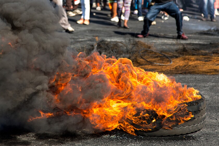 Protesters protest riot burning rubber tyres South Africa.jpg