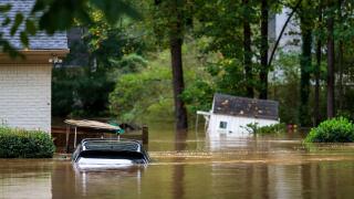 An vehicle, golf cart and playhouse are submerged from flooding Friday, Sept 27, 2024, in Atlanta. (AP Photo/Jason Allen)