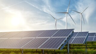 solar panels and wind generators under blue sky on sunset