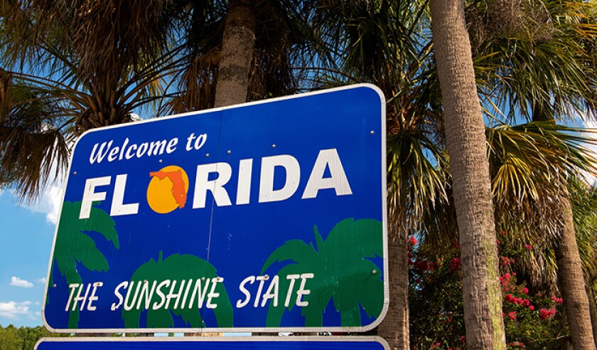 Welcome to Florida sign with palm trees in background