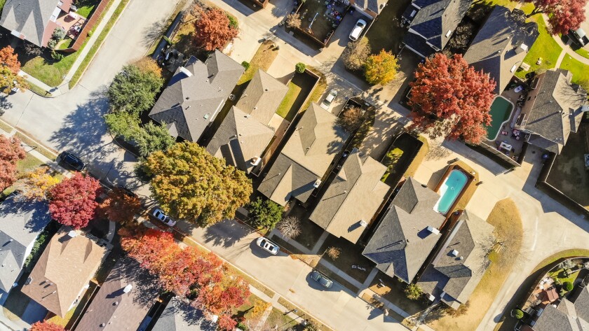Aerial view urban subdivision houses with pool and autumn leaves near Dallas