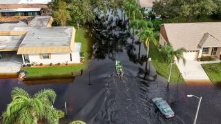 A member of the Pasco County Sheriff's Office goes out to help residents trapped in their homes as waters rise after Hurricane Milton caused the Anclote River to flood, Friday, Oct. 11, 2024, in New Port Richey, Fla. (AP Photo/Mike Carlson)