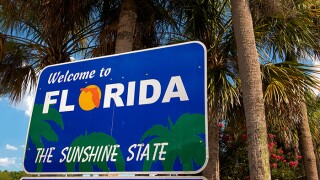 Welcome to Florida sign with palm trees in background