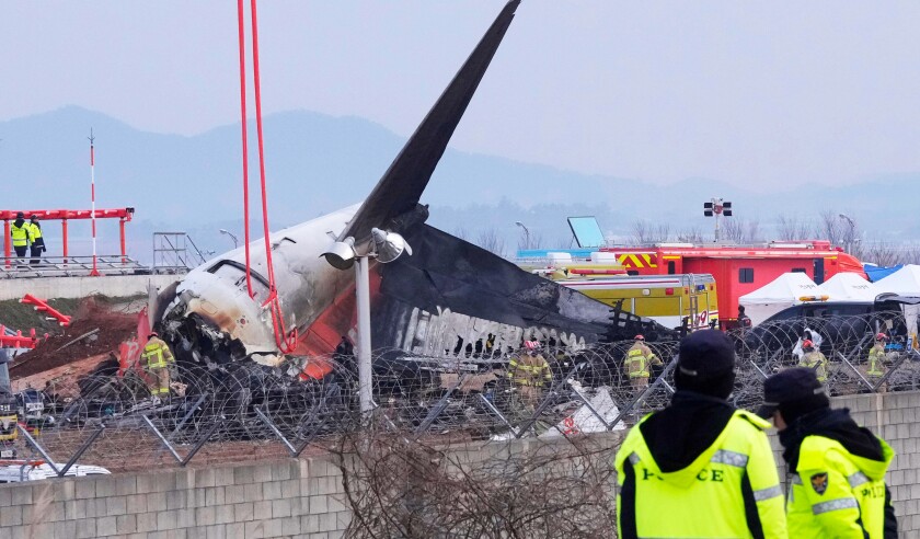 Rescue team members work at the site of a plane fire at Muan International Airport in Muan, South Korea, Monday, Dec. 30, 2024. (AP Photo/Ahn Young-joon) - Image ID: 2S0XE81