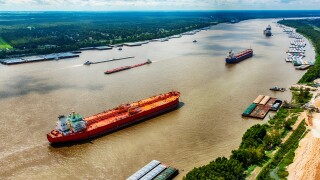 A line of oil tankers transporting fuel to the refineries located along the Mississippi River just north of New Orleans, Louisiana.jpg