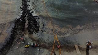 Workers clean the beach near Repsol's La Pampilla refinery after the recent oil spill that has caused an ecological disaster on the coast of Lima, in Ventanilla, Peru January 29, 2022. Picture taken with a drone January 29, 2022. REUTERS/Angela Ponce