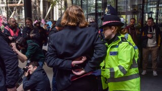 London, UK. 29th October 2024. Police officers arrest Extinction Rebellion activists who spray-painted the office building of insurance company WTW in the City of London, on the second day of their three-day protest calling on insurance companies to stop