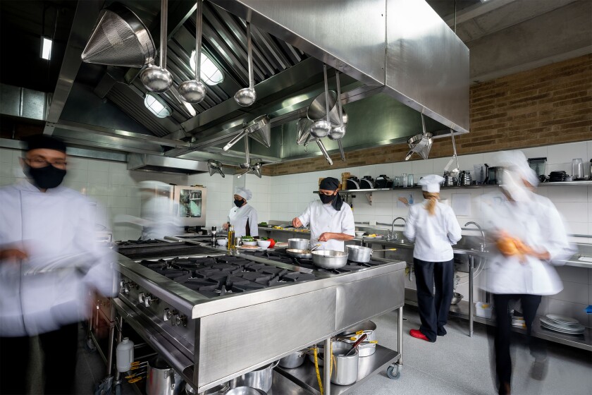 Chef working in a kitchen wearing facemask during the pandemic covid restaurant workers staff .jpg